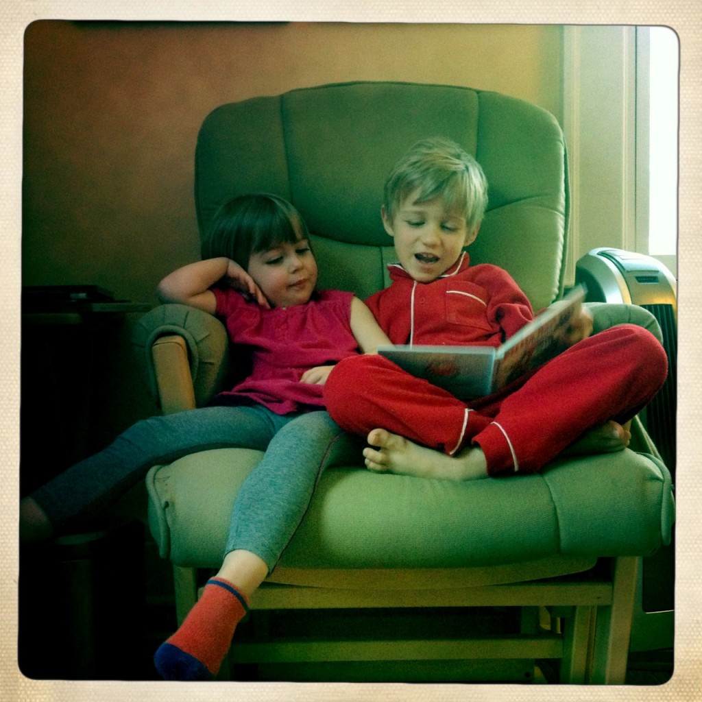 Big brother reading to little sister